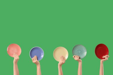 Yeşil arka planda farklı plakalı kadın elleri