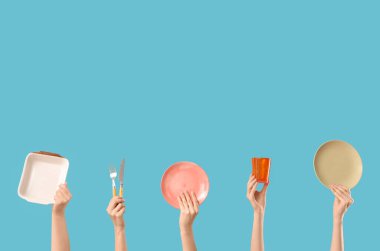 Tabakları, çatalı, bıçağı ve mavi arka planı olan kadın elleri.