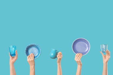 Mavi arka planda tabak, sürahi ve gözlüklü kadın elleri