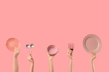 Tabak, kase, kaşık ve pembe arka planda cam olan kadın elleri.