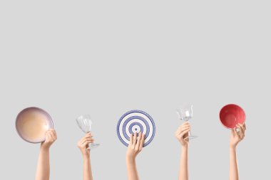 Beyaz arka planda tabak, kase ve gözlüklü kadın elleri