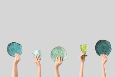 Beyaz arka planda tabak, bardak ve cam kaplı kadın elleri.