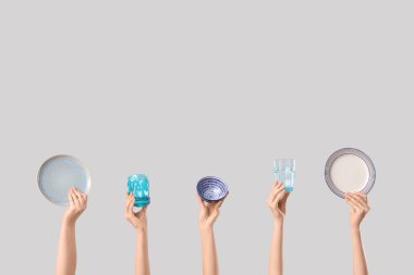 Beyaz arka planda tabak, kase ve gözlüklü kadın elleri