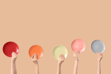 Bej arka planda farklı plakalı kadın elleri