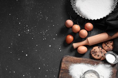 Siyah arka planda hamur için ahşap merdane ve malzeme