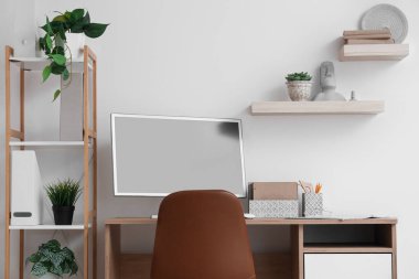 Çalışma yeri, modern bilgisayar, sandalye ve raf ünitesi olan şık bir ofis.