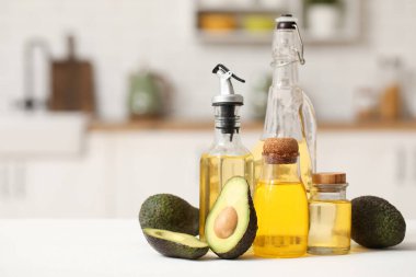 Mutfaktaki beyaz masada taze avokado yağı şişeleri.
