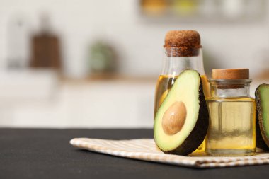 Mutfaktaki siyah masada taze avokado yağı şişeleri.