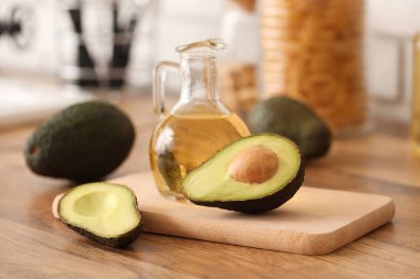 Bir sürahi taze yağ ve ahşap masa üzerinde avokado.