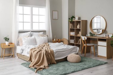 Yatak odasının içinde yatak odası, raf bölümü ve tuvalet masası var.