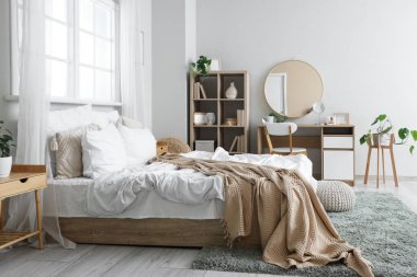 Yatak odasının içinde yatak odası, raf bölümü ve tuvalet masası var.