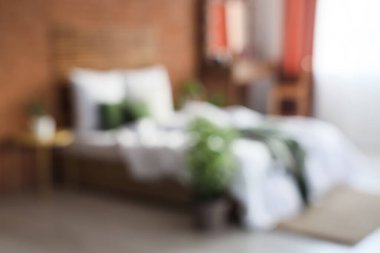 Yatak odası, tuvalet masası ve tuğla duvarın yanındaki yatak bulanık görünüyor.