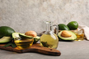 Gri zemin üzerinde avokado yağı olan kompozisyon
