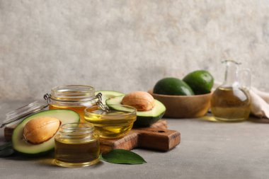 Gri zemin üzerinde avokado yağı olan kompozisyon