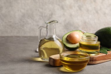 Gri zemin üzerinde avokado yağı olan kompozisyon