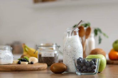 Mutfaktaki masada meyveli bir şişe chia tohumu yoğurdu.