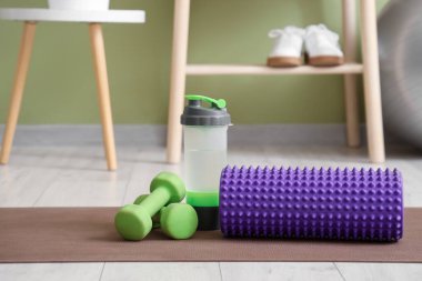 Köpük silindir, bir şişe su ve dambıl. Yakın çekim.