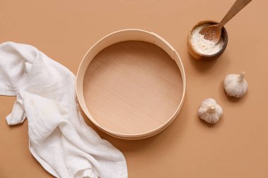 Tahta elek, bir kase un, sarımsak ve peçete.