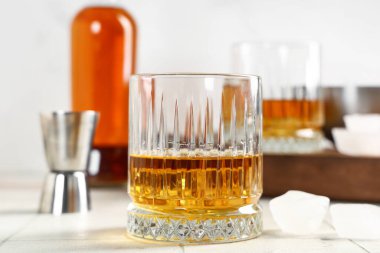 Masanın üzerinde bulanık arka planda bir bardak rom ve buz. Yakın çekim.