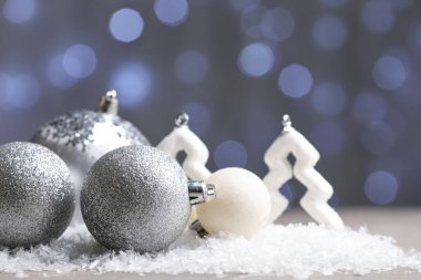 Masada bulanık ışıklara karşı dekorlu ve karlı Noel baloları