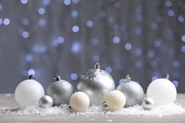 Bulanık ışıklara karşı masada karlı Noel topları