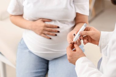 Klinikte neşter kullanan hamile bir kadın, yakın plan. Gebelik Diyabet Konsepti