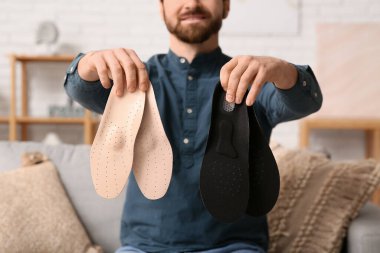 Evinde ortopedik tabanı olan genç bir adam, yakın plan.