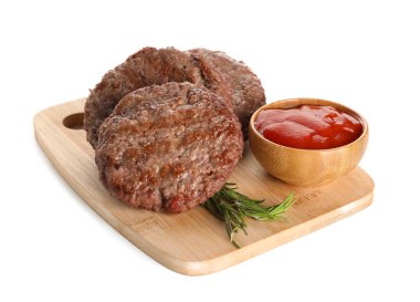 Lezzetli et pirzolaları, bir kase ketçap ve beyaz arka planda biberiye olan ahşap tahta.
