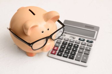 Beyaz arkaplanda hesap makinesi olan Piggy Bank