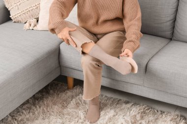 Ortopedik tabanı evdeki kanepeye koyan genç bir kadın.