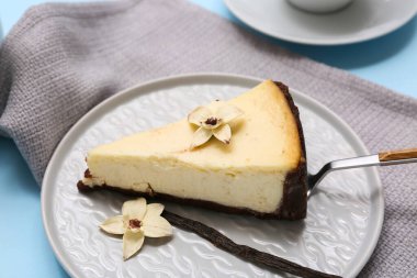 Mavi arka planda tatlı vanilyalı cheesecake tabağı, yakın plan.