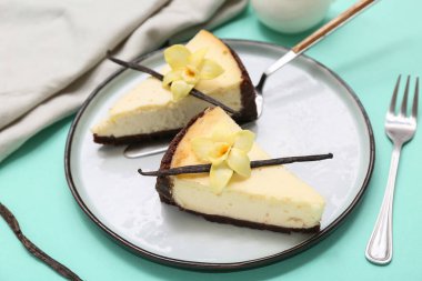Turkuaz arka planda tatlı vanilyalı cheesecake tabağı.