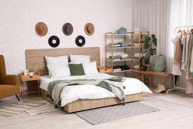 Rahat yataklı, elbiseli ve aksesuarlı modern yatak odası.