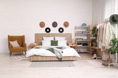 Rahat yataklı, elbiseli ve aksesuarlı modern yatak odası.