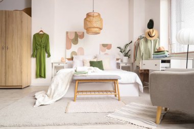 Rahat yataklı yatak odası ve elbiseli askı.