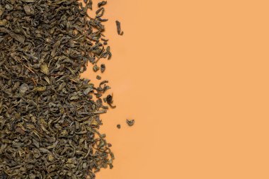 Kahverengi arka planda kurumuş yeşil çay yaprakları