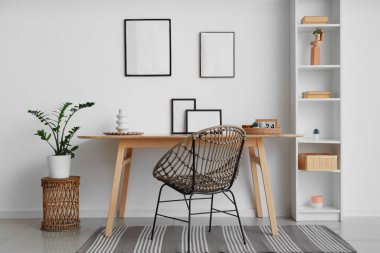 Çalışma yeri ve boş fotoğraf çerçeveleri odadaki beyaz duvarda.