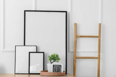 Odadaki beyaz duvarın yanındaki boş fotoğraf çerçeveleri