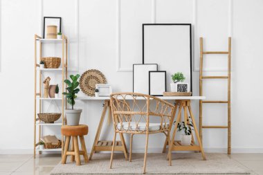 Odada beyaz duvarın yanında boş fotoğraf çerçeveleri olan işyeri