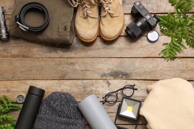 Ahşap arka planda seyahat için giysiler, ayakkabılar ve eşyalar ile kompozisyon