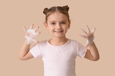 Bej arka planda köpüklü küçük kız