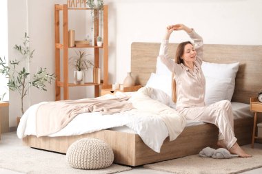 Genç bir kadının yatak odasında uzandığı bir sabah.