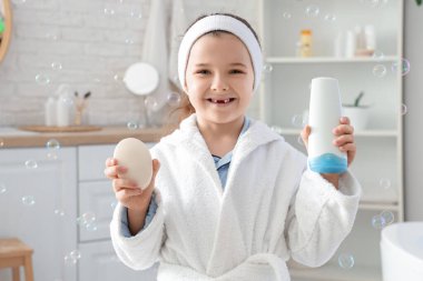 Banyosunda sabun ve duş jeli olan tatlı küçük bir kız.
