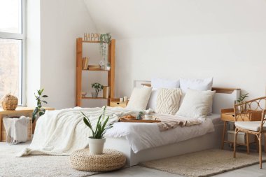 Modern yatak odasının içinde büyük konforlu yatak ve raf ünitesi.