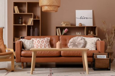 Oturma odasındaki kanepenin yanındaki kahve masasındaki vazoda çiçek.