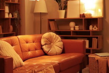 Oturma odasının içinde rahat bir kanepe, sepet ve parlayan bir lamba.