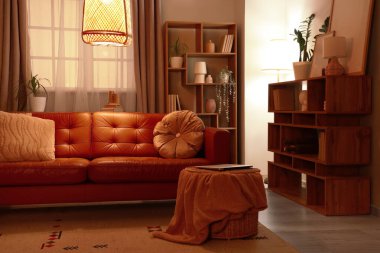 Rahat bir kanepe, oturma odasının içinde ekose ve dizüstü bilgisayarlı bir sepet.