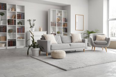 Kanepesi, koltuğu ve kitaplığı olan modern oturma odasının içinde.