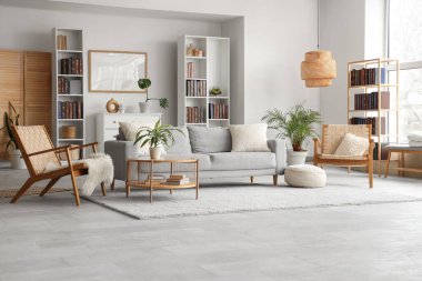 Kitaplıklar, rahat kanepe, hasır koltuklar ve modern oturma odasının içindeki kahve masası.