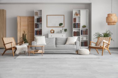 Kitaplıklar, rahat kanepe, hasır koltuklar ve şık oturma odasının içindeki kahve masası.